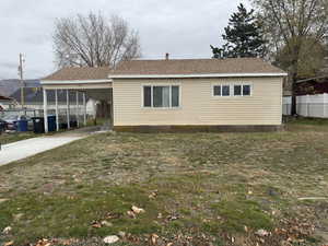 View of front of house with roof with shingles, concrete driveway, and a carport