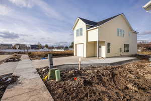 View of home's exterior featuring driveway, a garage, and a patio