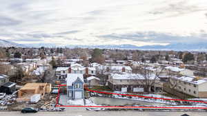 Snowy aerial view with a mountain view and a residential view