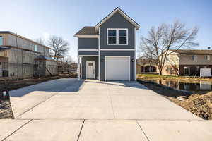 View of front of house with an attached garage and driveway