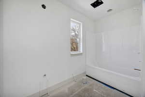 Bathroom featuring baseboards and bathtub / shower combination
