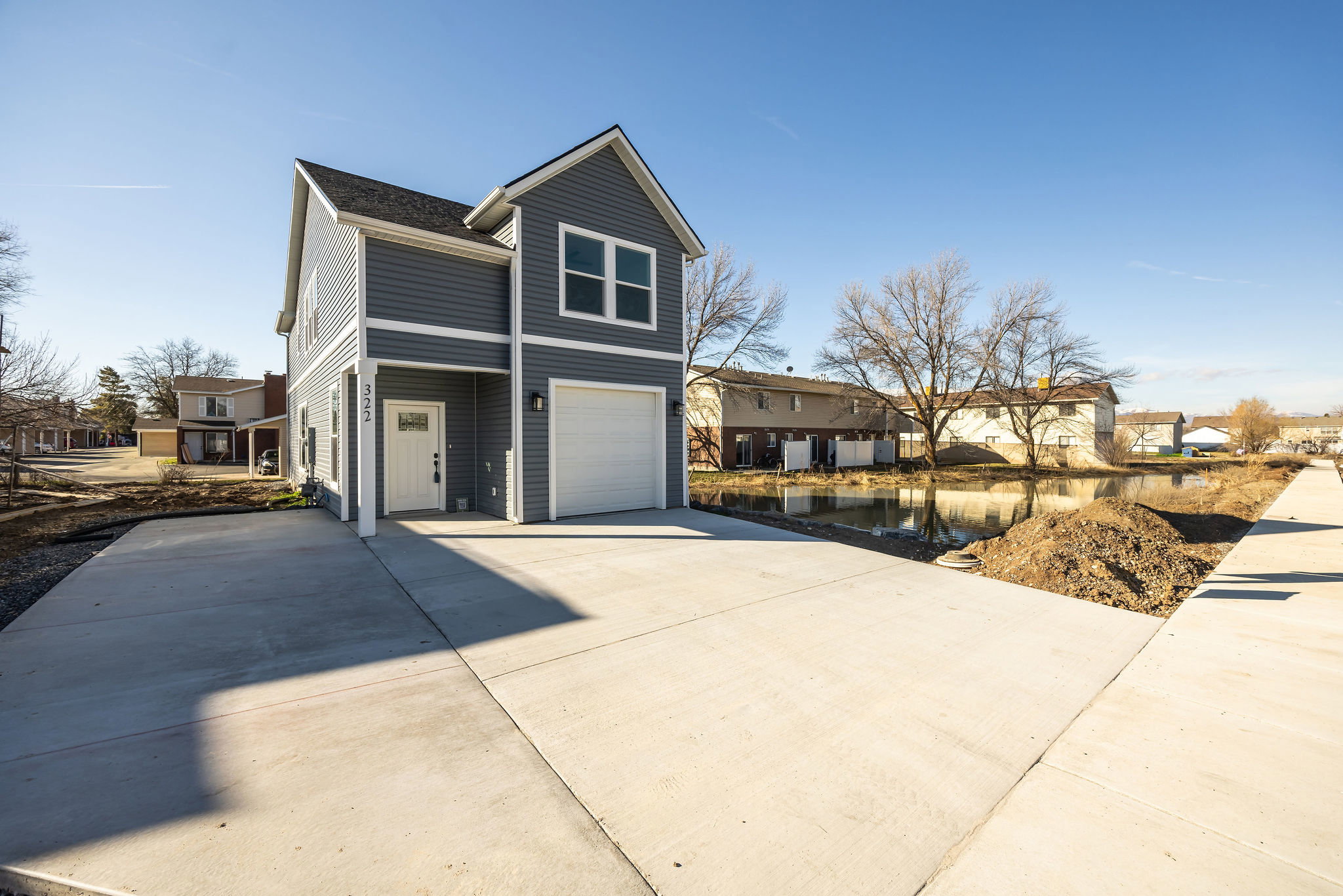 View of front of house featuring concrete driveway, an attached garage, and a residential view