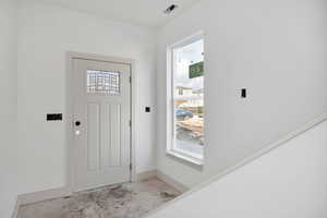 Entrance foyer featuring unfinished concrete floors