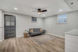Living area with light wood-style flooring, recessed lighting, and a ceiling fan