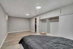 Bedroom with light wood-type flooring and a closet