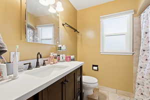 Full bath with vanity, light tile patterned flooring, and a shower with curtain