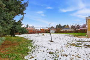 Snowy yard with a shed and a fenced backyard