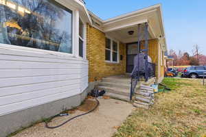 Entrance to property featuring brick siding and a yard