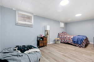Bedroom with wood finished floors and wooden walls