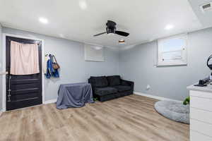 Sitting room with light wood finished floors, ceiling fan, and recessed lighting
