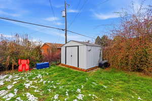 View of green lawn with a storage unit