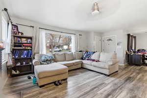 Living area featuring wood finished floors and a ceiling fan