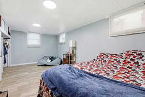 Bedroom featuring light wood-style flooring and wooden walls