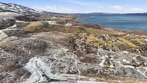 Snowy aerial view featuring a water and mountain view