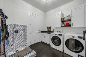 Laundry room with concrete floors, cabinet space, and washer and dryer