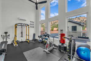 Gym with a high ceiling, ceiling fan, and a wall unit AC