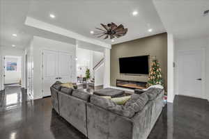 Living area with concrete flooring, recessed lighting, and stairway