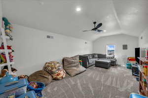 Living room with vaulted ceiling, carpet, and ceiling fan