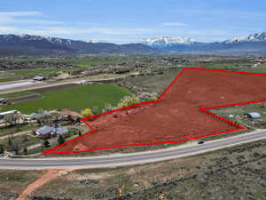 Overview of rural landscape featuring a mountainous background and property parcel outlined