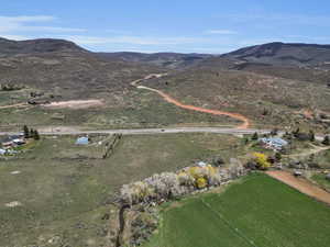 Aerial view of property and surrounding area featuring a mountain backdrop and rural landscape
