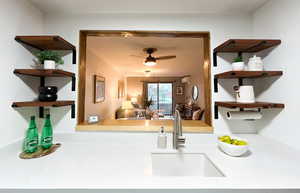 Kitchen view of open shelves and a ceiling fan