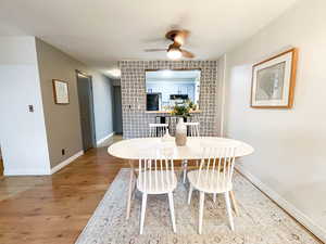 Dining space with a ceiling fan and light wood-style floors