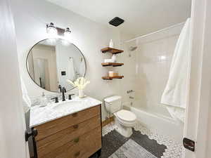 Full bath with vanity, shower / tub combo, and dark tile patterned flooring