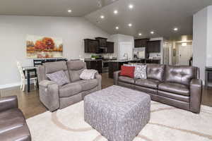 Living room featuring lofted ceiling, light wood-style floors, and recessed lighting