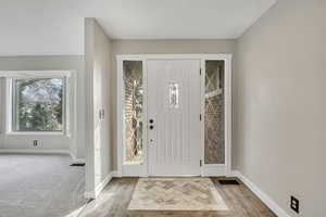 Foyer entrance with baseboards and wood finished floors