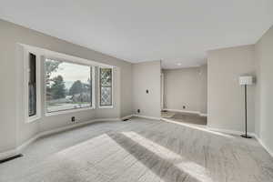 Unfurnished room with light colored carpet and recessed lighting