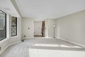 Spare room featuring carpet floors, stairs, and recessed lighting