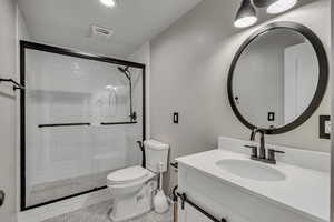 Full bath featuring vanity, light tile patterned floors, and a stall shower