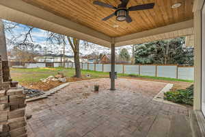 Fenced backyard with a patio area and a ceiling fan