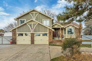 View of front of home with concrete driveway, board and batten siding, and brick siding