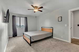Bedroom with light colored carpet and ceiling fan