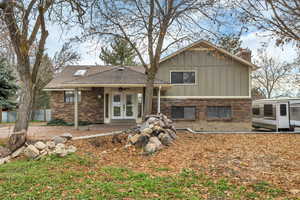 Back of property featuring brick siding, french doors, board and batten siding, and a patio