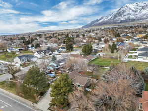 Aerial view of property and surrounding area with nearby suburban area and a mountain backdrop