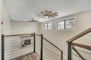 Stairs featuring wood finished floors and ceiling fan