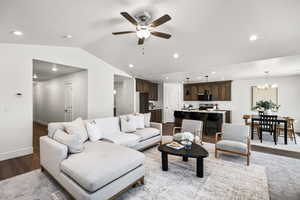 Living area featuring recessed lighting, ceiling fan, a chandelier, vaulted ceiling, and wood finished floors