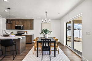 Kitchen featuring recessed lighting, decorative light fixtures, dark brown cabinetry, stainless steel appliances, and a textured ceiling