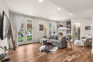 Living area with french doors, light wood finished floors, and recessed lighting