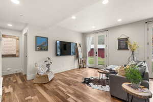 Living room featuring light wood-type flooring, recessed lighting, and french doors