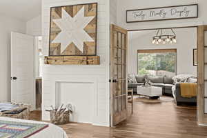 Bedroom with lofted ceiling, hardwood / wood-style flooring, and a chandelier