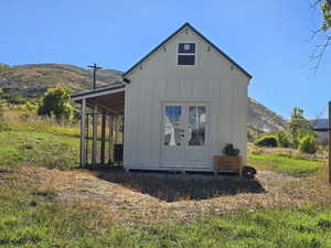 View of property exterior with board and batten siding, a mountain view, and an outdoor structure