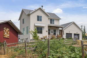 View of front facade with roof with shingles, covered porch, a garage, board and batten siding, and a chimney