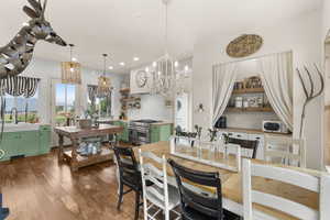 Dining room with light wood-type flooring, recessed lighting, and a chandelier