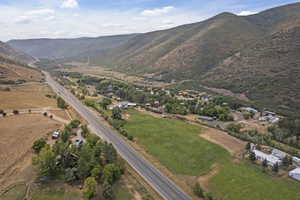 Aerial view of property and surrounding area with a mountain backdrop