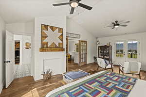 Bedroom featuring french doors, lofted ceiling, access to exterior, wood finished floors, and a ceiling fan