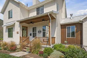 View of front facade featuring a porch, ceiling fan, and a chimney