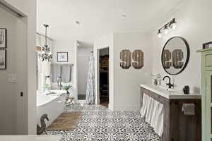 Full bathroom featuring a freestanding tub, a shower stall, vanity, a spacious closet, and light tile patterned flooring